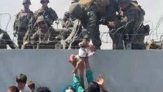 Una familia, presa de la desesperación, entrega a su bebé a los soldados estadounidenses en el muro del aeropuerto.