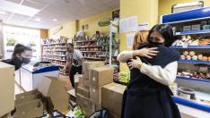 Svitlana Berlus abraza a Natalia Liudmyla, en presencia de Yuri Isayev, en la tienda Kozak, donde se recoge material para Ucrania, en Zaragoza