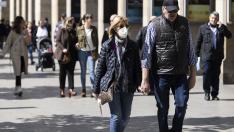 Una pareja camina por Zaragoza con diferentes opciones sobre el uso de la mascarilla.