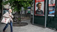 Un hombre camina junto a un kiosco en el que figura una portada del seminario Le Point, que informa de la victoria de Macron, este lunes en París.