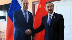 Los ministros de Exteriores de Rusia y China se estrechan la mano.