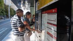 Dos usuarios del tranvía recargan su tarjeta en la parada de plaza de España, ayer