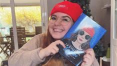 Andrea Izquierdo sostiene una copia de su libro 'La chica del zodiaco. Segunda parte'.