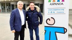 Juan Carlos Acín y Roberto Ciria junto a cartel de Aspanoa colocado en el exterior del Palacio de Congresos de Huesca.
