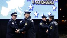 El ministro croata del Interior, Davor Bozinovic, y su homólogo esloveno, Sanja Ajanovic Hovnik, levantan juntos la valla en la frontera entre Croacia y Eslovenia.