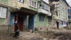 La anciana Alexandra sale de su casa en Kostiantynivka a dejar la basura