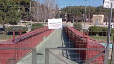 Una valla impide el paso por esta pasarela peatonal sobre el río Isuela de Huesca.