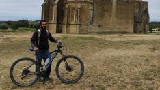 Ender, con su bicicleta, y la iglesia de San Miguel de Foces.