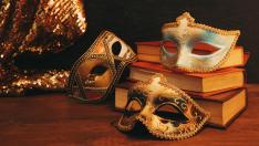 mascaras-azules-doradas-libros-antiguos-textiles-lentejuelas-brillantes-escritorio-madera