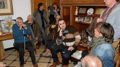 José Iranzo, a la izquierda, escucha atentamente en el salón de su casa al cantador Nacho del Río dedicándole una jota.