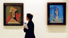 Una visitante del museo, entre obras de Picasso, a la izquierda, y Dalí ('Aparato y mano')