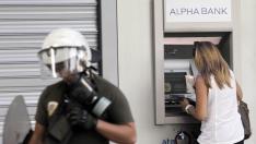 Una mujer saca dinero en un cajero de Atenas