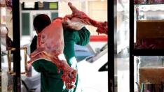 Un carnicero transporta un cordero sacrificado orientado a la Meca