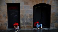 Dos personas descansan tras las fiestas en Pamplona