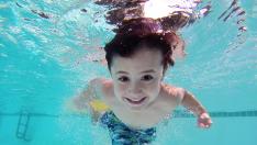 Un niño jugando en la piscina.