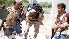 Un soldado del régimen sirio carga con un compañero herido por el Estado Islámico en la zona que bombardea EE.UU.