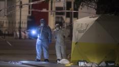 Oficiales de policía investigan en la escena donde una mujer murió y varias personas resultaron heridas por un sospechoso ataque con cuchillo