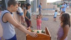 Una niña lanza la ficha en el popular juego de la rana, una de las actividades más practicadas.