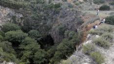 Varios cámaras de televisión toman imágenes de la sima donde agentes del Servicio de Protección de la Naturaleza (Seprona) han localizado el cadáver desnudo de una joven en las inmediaciones de la localidad valenciana de Chella.