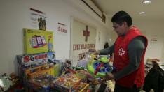 Un voluntario de Cruz Roja almacena los juguetes recogidos.