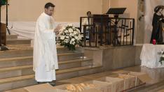 El párroco de Santa Rita, bendiciendo el pan que se entregó tras la misa.