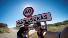 Laura Uranga y Pablo Ferrer junto al cartel de entrada a Castelserás