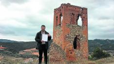 El alcalde de Cosuenda, Óscar Lorente, muestra las escrituras del terreno, junto a la torre.