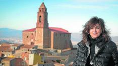 La alcaldesa posa delante de la iglesia de Olvés, cuya restauración continúa pendiente.