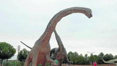 Un visitante de Dinópolis fotografía la reproducción de un Tastavinsaurus y un Baryonyx luchando entre sí.