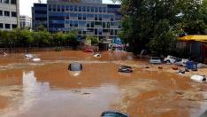 Varios vehículos han sido arrastrados por la fuertes lluvias en una calle inundada en Maroussi