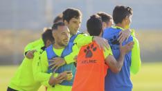Algunos futbolistas de la SD Huesca se abrazan durante un ejercicio del entrenamiento del pasado viernes.