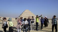 Un grupo de turistas fotografía las pirámides en Guiza (Egipto).
