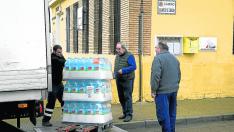 Dos vecinos de El Lugarico de Cerdán, Pepe Marqués y Ricardo Cobo, ayudaron a descargar este jueves las garrafas en las antiguas escuelas