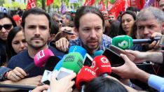 El secretario general de Podemos, Pablo Iglesias (c), en presencia del líder de IU, Alberto Garzón (i), hace declaraciones a los medios antes de participar en la manifestación convocada en Madrid con motivo del Primero de Mayo