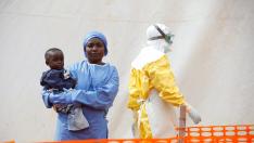FILE PHOTO: Mwamini Kahindo, an Ebola survivor working as a caregiver to babies who are confirmed Ebola cases, holds an infant outside the red zone at the Ebola treatment centre in Butembo, Democratic Republic of Congo, March 25, 2019. REUTERS/Baz Ratner/File Photo [[[REUTERS VOCENTO]]] HEALTH-EBOLA/SOCIETY