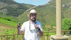 Fernando Mora, con una copa junto al peirón instalado en la finca que da nombre al vino, El Jardín de las Iguales.