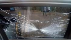 Estado en el quedó el cristal de la ventanilla del coche oficial de Olona por el golpe de un cencerro.