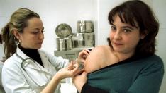 Una joven se vacuna contra el sarampión en un centro de salud.