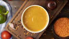 Red lentil soup in disposable cup bowl served with green vegetables. image