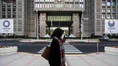 FILE PHOTO: A woman wearing a protective face mask, following an outbreak of the coronavirus, walks past banners of the upcoming Tokyo 2020 Olympic and Paralympic Games outside the Tokyo Metropolitan Government building in Tokyo