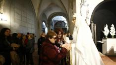 Una afiliada de la ONCE palpa a la Vuirgenla Virgen Blanca de la cofradía de El Silencio