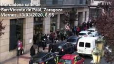 Puerta del Mercadona de San Vicente de Paúl, Zaragoza, 08.55. Decenas de personas hacían fila este viernes a las puertas de este supermercado a la espera de su apertura, a las 09.00, para poder hacer sus compras.