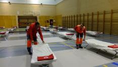 El Equipo de Respuesta Inmediata de Emergencia de Cruz Roja en Huesca ha estado montando este martes las camas y una carpa en el pabellón de la Universidad.