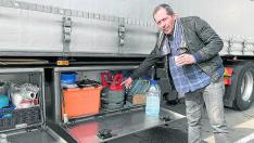 El camionero portugués Víctor Silva muestra su cocina de gas mientras toma un café