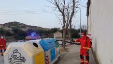 Bomberos voluntarios limpiando los contenedores de Almudévar.