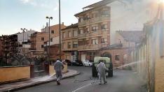 Dos operarios fumigan las calles de Alcorisa con un producto desinfectante.