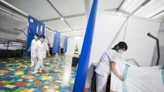 Una trabajadora prepara una de las 35 primeras camas del hospital de campaña de la Multiusos
