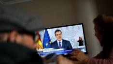 An elderly couple eats lunch at their home as they watch Spanish Prime Minister Pedro Sanchez on a television screen during a live news conference, due to the coronavirus disease (COVID-19) outbreak, in Ronda, southern Spain April 4, 2020. REUTERS/Jon Nazca [[[REUTERS VOCENTO]]] HEALTH-CORONAVIRUS/SPAIN