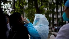 A woman receives a nucleic acid test for COVID-19 on a street near a hospital after the lockdown was lifted in Wuhan