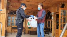 Un agente de la Policía Nacional entrega material al director de la residencia La Abubilla, en Yéqueda